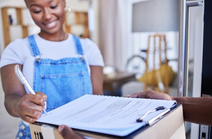 A client signing paperwork after a delivery